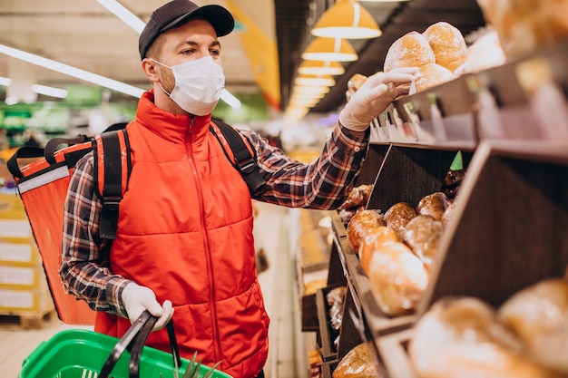 Mężczyzna dostarczający jedzenie, kupujący produkty w sklepie spożywczym