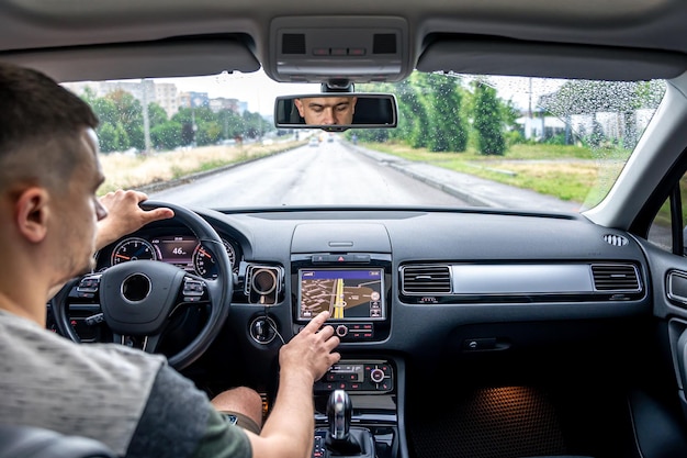 Bezpłatne zdjęcie mężczyzna dotykający ekranu systemu nawigacji gps w swoim samochodzie