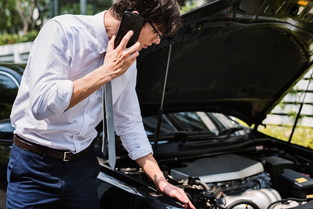 Mężczyzna dzwoni po pomoc w naprawie swojego samochodu