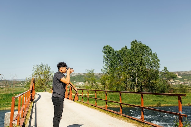 Mężczyzna fotograf turysta z kamerą strzela piękną przyrodą