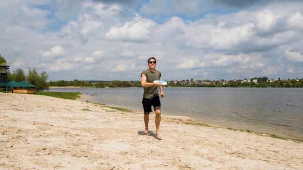 Mężczyzna frisbee gracz na piaskowatej plaży