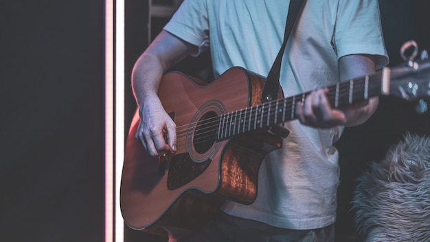 Mężczyzna Gra Na Gitarze Akustycznej W Ciemnym Pokoju. Występ Na żywo, Koncert Akustyczny, Praktyka.