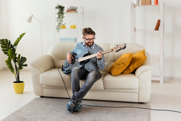 Mężczyzna gra na gitarze elektrycznej w domu