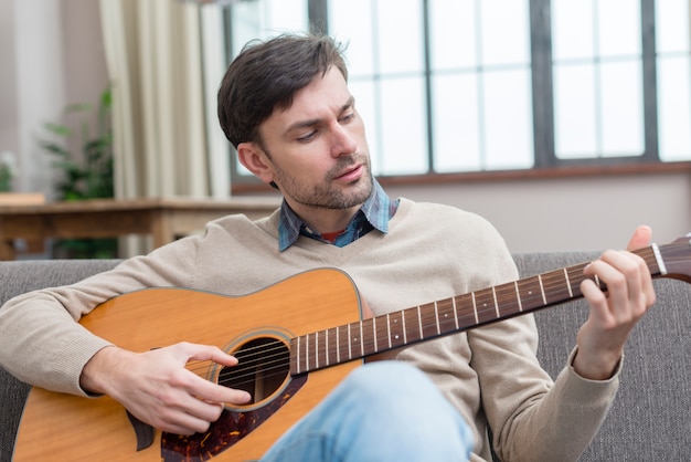 Mężczyzna gra na gitarze średni strzał