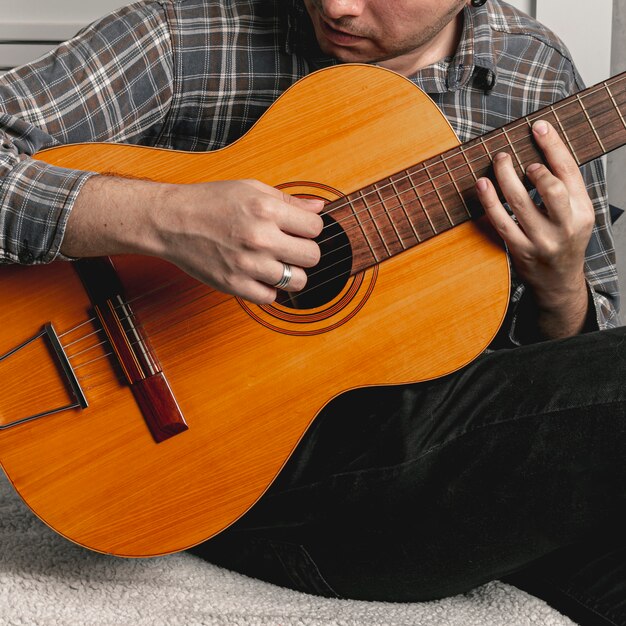 Mężczyzna gra na starej gitarze akustycznej