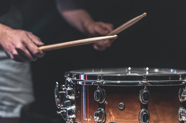 Bezpłatne zdjęcie mężczyzna gra na werblu pałkami, perkusista gra na instrumencie perkusyjnym, z bliska.