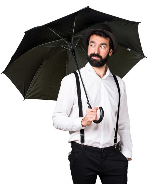 Mężczyzna hipster z brodą trzyma parasol