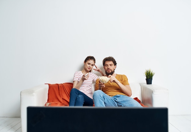 Mężczyzna i kobieta na kanapie oglądają film rozrywka w domu w czasie wolnym