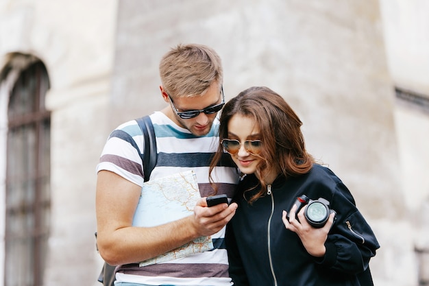 Mężczyzna I Kobieta Oglądać Coś W Telefon Stojący Z Mapy Turystyczne