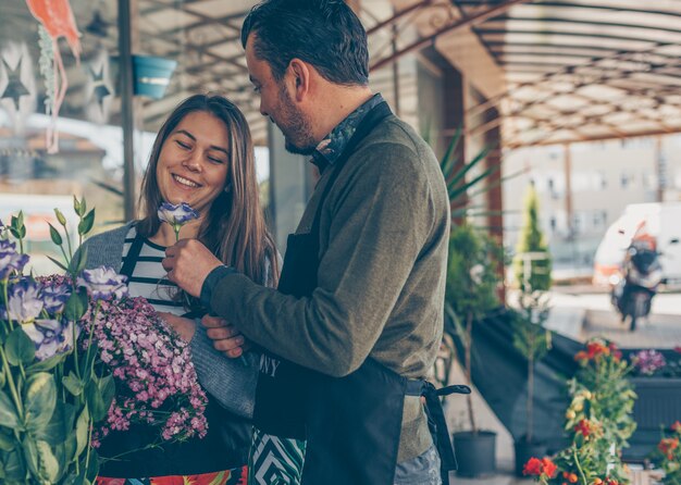 mężczyzna i kobieta, patrząc na kwiaty w kwiaciarni w ciągu dnia patrząc szczęśliwy