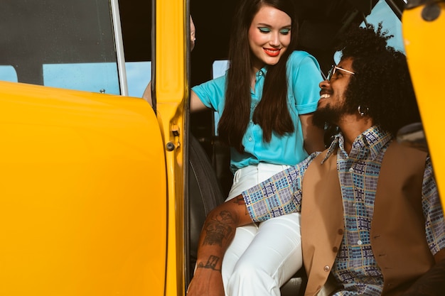 Mężczyzna i kobieta pozują w stylu retro z samochodem
