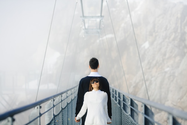 Mężczyzna i kobieta stojąc z powrotem na wysoki most linowy