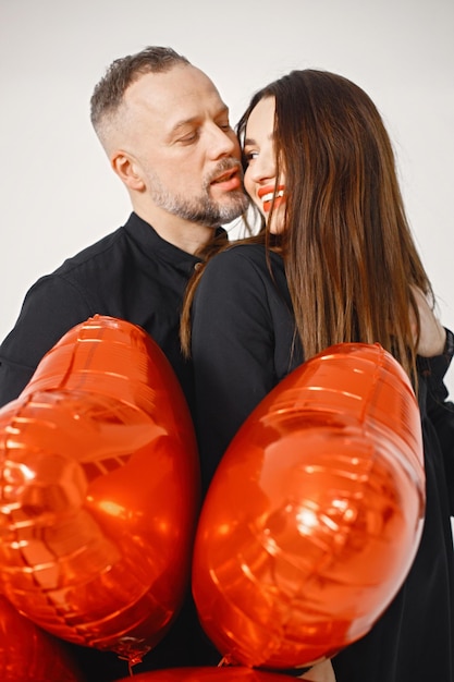 Mężczyzna I Kobieta Trzymają Pęk Czerwonych Balonów W Kształcie Serca I Pozują W Studio