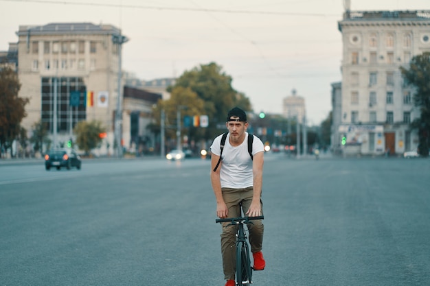 Mężczyzna Jedzie Bicykl W Miastowym Miasta Mienia Rękach Na Kierownicie