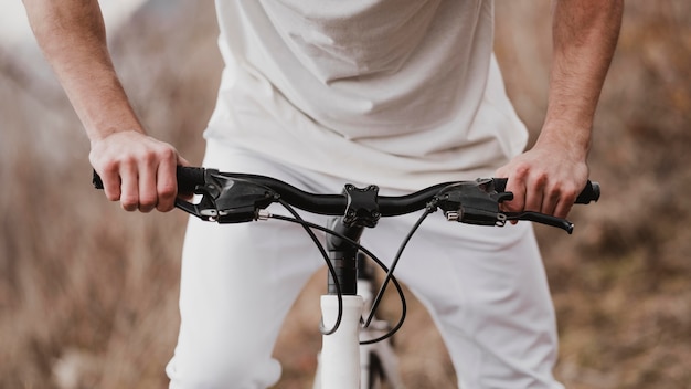 Mężczyzna jedzie na rowerze w białych ubraniach