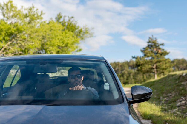 Mężczyzna jedzie samochód z okularami przeciwsłonecznymi