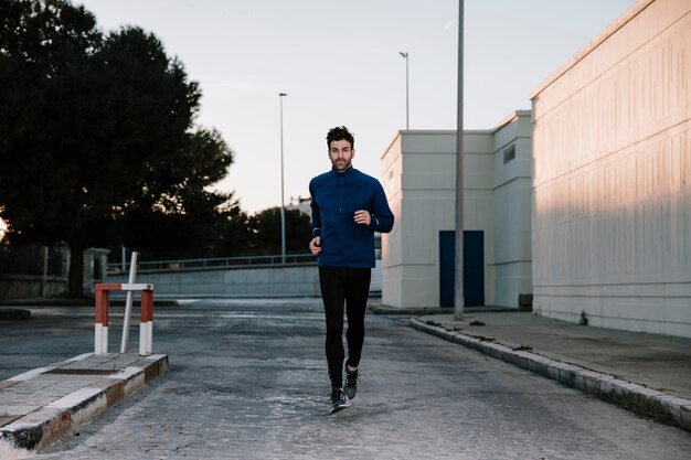 Mężczyzna jogging na ulicy w zmierzchu