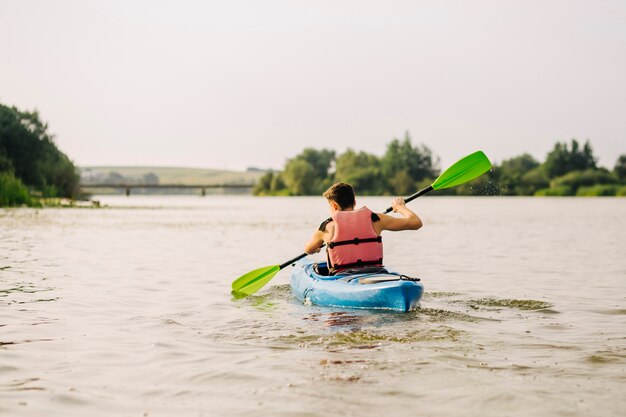 Mężczyzna kayaking na jeziorze z paddle