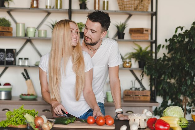 Mężczyzna kochający jej kobiety tnących warzywa w kuchni