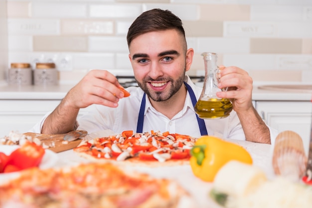 Bezpłatne zdjęcie mężczyzna kulinarna pizza z pomidorami