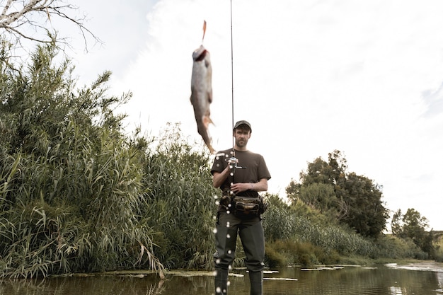 Mężczyzna łowi przy rzeką