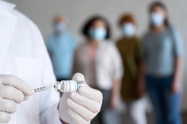 Bezpłatne zdjęcie mężczyzna medyk trzymający fiolkę szczepionki ze strzykawką