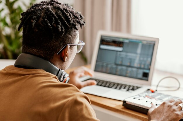 Mężczyzna muzyk w domu za pomocą laptopa