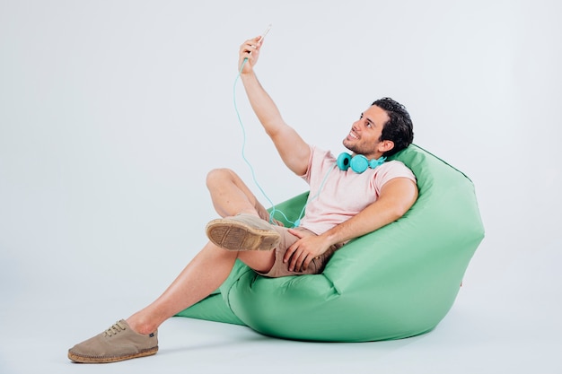 Mężczyzna na kanapie biorąc selfie z smartphone