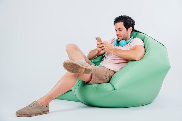 Mężczyzna na kanapie wpisując na smartphone