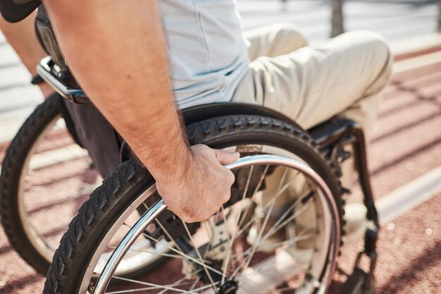 Mężczyzna na wózku inwalidzkim na zewnątrz z bliska
