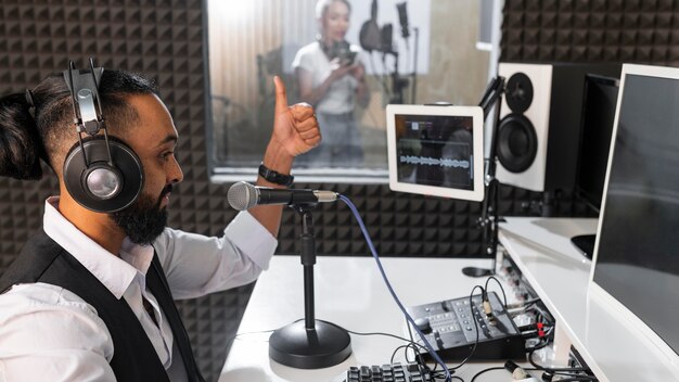 Mężczyzna nagrywa kobietę śpiewającą w stacji radiowej