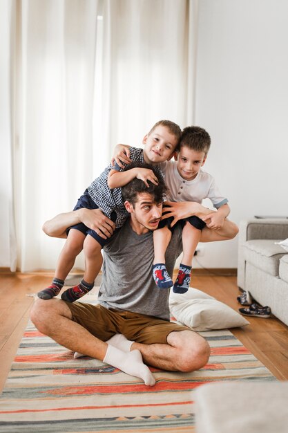 Mężczyzna niosący swoich dwóch synów na ramieniu
