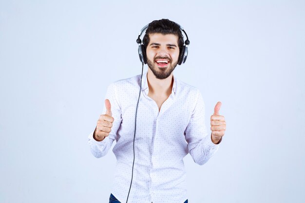 Mężczyzna noszący słuchawki i cieszący się muzyką