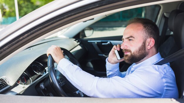 Mężczyzna opowiada na telefonie komórkowym podczas gdy jadący samochód