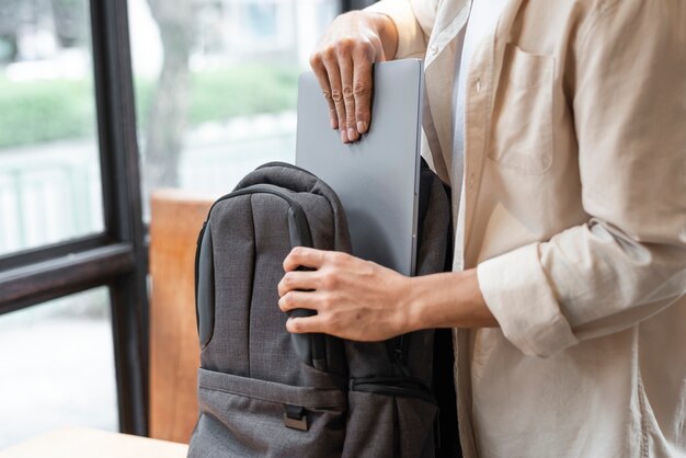 Mężczyzna pakuje laptopa do torby