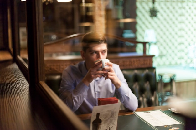 Mężczyzna pije gorącego napój w ładnej restauraci