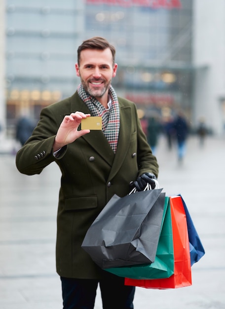 Bezpłatne zdjęcie mężczyzna płaci kartą kredytową za zimowe zakupy
