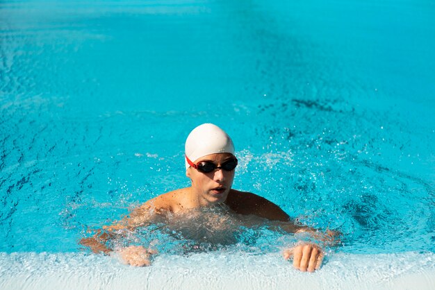 Mężczyzna pływak z okularami w basenie i miejsce na kopię
