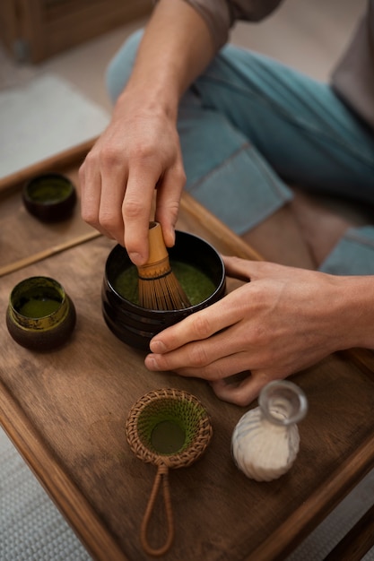 Mężczyzna pod dużym kątem z herbatą matcha