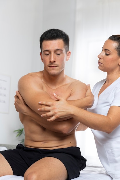 Mężczyzna podczas masażu podczas sesji fizjoterapeutycznej