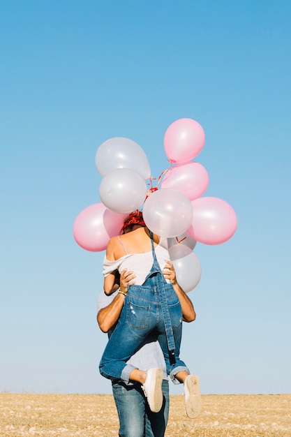 Mężczyzna podnośna kobieta z balonami