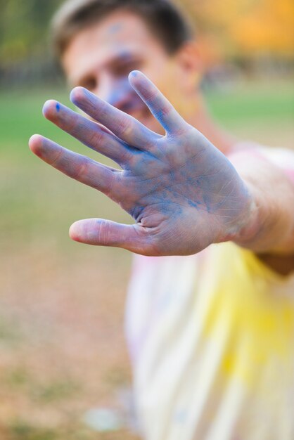 Mężczyzna pokazuje błękitną rękę przy holi