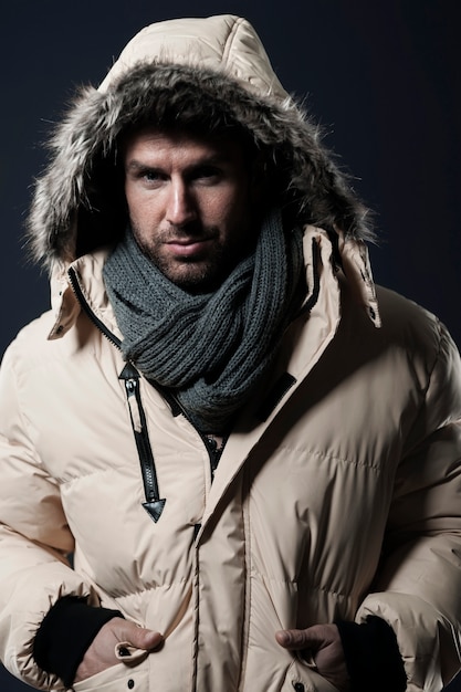 Bezpłatne zdjęcie mężczyzna pozuje i nosi kurtkę zimową