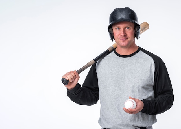 Bezpłatne zdjęcie mężczyzna pozuje z baseball piłką i kapeluszem