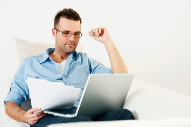 Mężczyzna pracujący w domu z laptopem