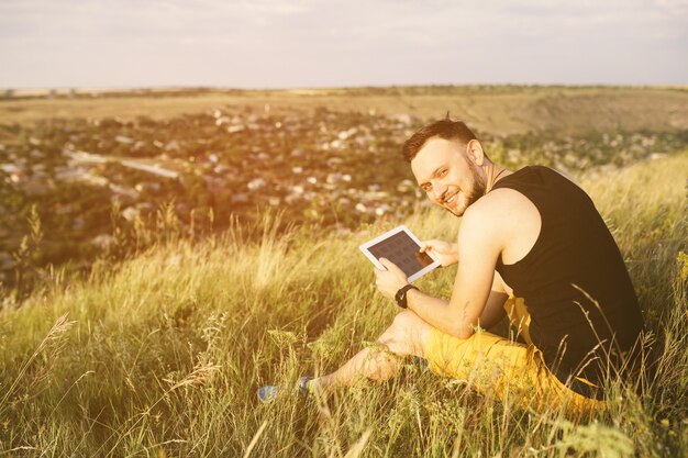 Mężczyzna pracuje outdoors z pastylka ochraniaczem. Filtr retro vintage instagram