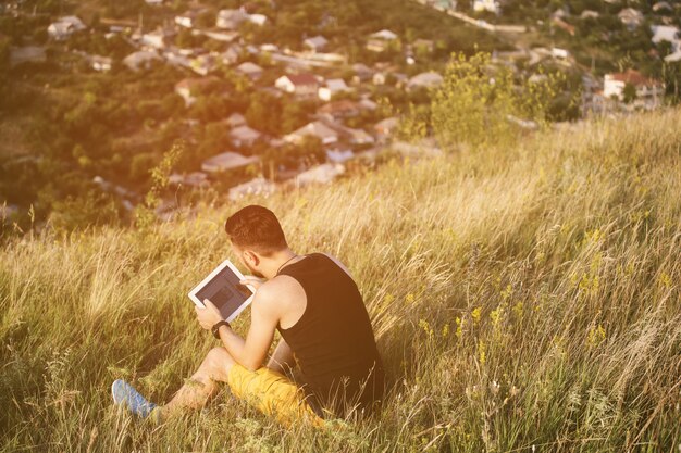 Mężczyzna pracuje outdoors z pastylka ochraniaczem. Filtr retro vintage instagram