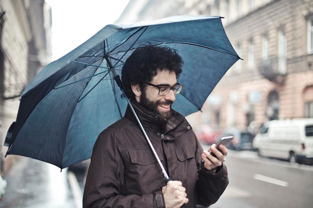 mężczyzna przy telefonie w deszczu