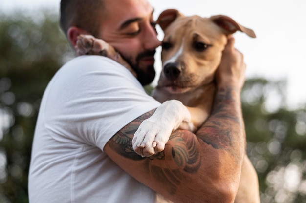 Bezpłatne zdjęcie mężczyzna przytulający swojego przyjaznego pitbulla