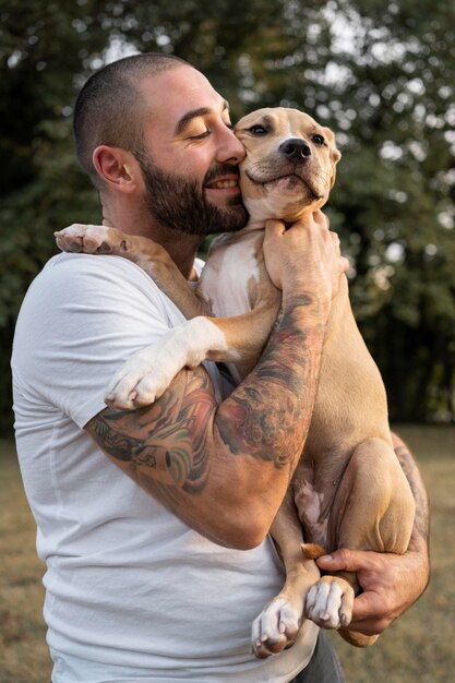 Mężczyzna przytulający swojego przyjaznego pitbulla